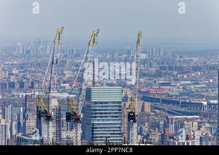 La couronne de verre de la Bloomberg Tower, située au 731 Lexington Avenue, semble assiégée par les grues de construction voisines de la section Midtown East de Manhattan. Banque D'Images