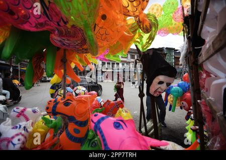 Srinagar, Inde. 22nd avril 2023. Une femme passe devant la rue où le vendeur de rue a gardé des masques de jouet pour exposition devant Eid Al-Fitr qui marque la fin du mois Saint du Ramadan à Srinagar sur 22 avril 2023. (Photo de Mubashir Hassan/Pacific Press) Credit: Pacific Press Media production Corp./Alay Live News Banque D'Images