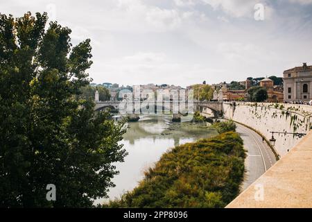 Coucher de soleil sur le Tibre à Rome, en Italie, une soirée nuageux avec réflexion dans l'eau tout en traversant le pont sur une Europe Vacation Banque D'Images