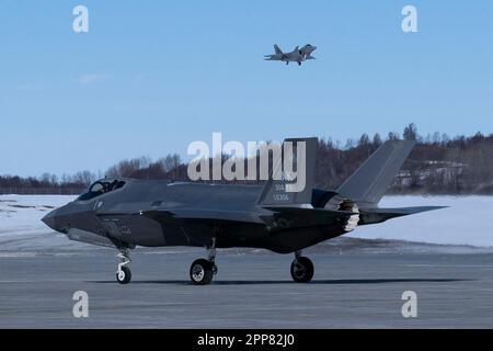 A ÉTATS-UNIS Force aérienne F-35A Lightning II affecté à la 354th Escadre Fighter, base aérienne d'Eielson, taxis, tandis qu'un F-22 Raptor affecté aux terres de la 3rd Escadre pendant l'Arctic Gold 23-2 à la base conjointe Elmendorf-Richardson, Alaska, 18 avril 2023. AG 23-2, une continuation de AG 23-1, a aidé à perfectionner et à former les capacités Agile combat Employment de l'aile pour mener des opérations de combat à partir de plusieurs endroits tout en testant les capacités de commandement et de contrôle. (É.-U. Photo de la Force aérienne par Airman 1st Class Julia Lebens) Banque D'Images