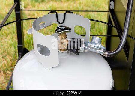 Bouteille de gaz propane avec flexible et régulateur pour barbecue. Sécurité au gril, inspection et stockage de l'équipement GPL Banque D'Images