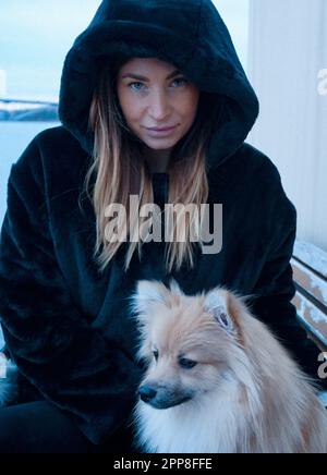 Une femme avec son chien pendant l'hiver Banque D'Images