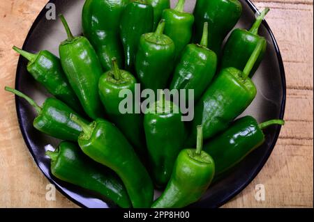 Pementos doux au poivre de padron vert frais, prêts à griller ou à frire avec de l'huile d'olive, en-cas traditionnel en Galice, Espagne. Banque D'Images