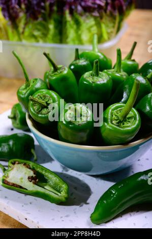 Pementos doux au poivre de padron vert frais, prêts à griller ou à frire avec de l'huile d'olive, en-cas traditionnel en Galice, Espagne. Banque D'Images