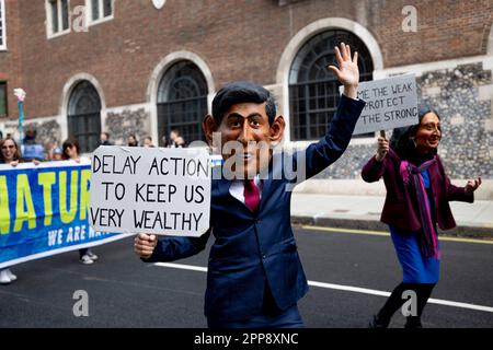 Londres, Royaume-Uni. 22nd avril 2023. Un manifestant porte un costume représentant le Premier ministre britannique Rishi Sunak et tient un écriteau pour exhorter le gouvernement britannique à considérer la crise climatique comme une question d'urgence lors de la marche à Westminster. Extinction les rébellions, un groupe de masse d'activistes de différentes disciplines, dont la principale préoccupation est la crise climatique, poursuivent le deuxième jour de leur campagne de masse le jour de la Terre. C'est la première campagne depuis que le groupe s'est engagé à s'éloigner des méthodes perturbatrices controversées depuis la fin de l'année dernière. Crédit : SOPA Images Limited/Alamy Live News Banque D'Images