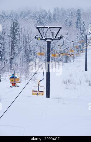 Station de ski d'hiver Teletsky Altai près d'Iogach. Ascenseur sur le mont et sur fond de forêt sous les chutes de neige. Banque D'Images