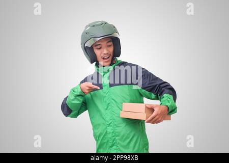 Portrait d'un pilote de messagerie en ligne asiatique portant une veste et un casque verts et livrant le colis et la boîte pour le client. Image isolée sur fond blanc Banque D'Images