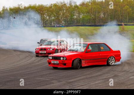 BMW 325i se Red Saloon 1988 80s 2494 cc, caoutchouc et pneus brûlants hurlant dans le circuit de course de trois Sœurs 3 à Wigan, dans le Lancashire au Royaume-Uni Banque D'Images