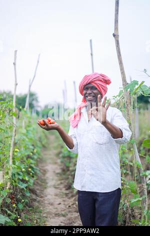 Agriculteur indien tenant la tomate entre les mains, fermier heureux Banque D'Images