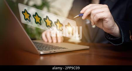 Concept d'évaluation client. Homme d'affaires utilisant un ordinateur portable avec une note d'étoiles Banque D'Images