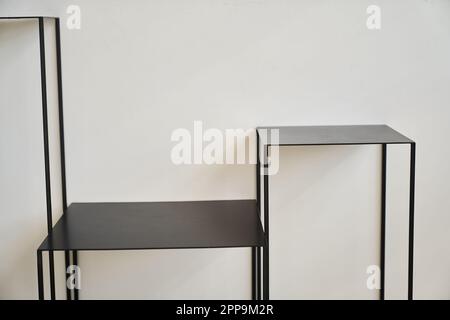 Tables en métal noir sur fond blanc, mise en page pour votre produit, espace pour votre conception, podium, table en métal peint avec espace pour le texte. Photo de haute qualité Banque D'Images