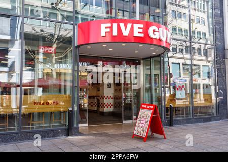 Stuttgart, Allemagne - 10 avril 2023: Five Guys fast food restaurant hamburger marque avec logo à Stuttgart, Allemagne. Banque D'Images