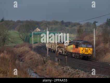 Colas Railfreight classe 56 locomotive 56096on la ligne principale de la côte ouest à Cumbria avec un train transportant de nouveaux rails pour le réseau ferroviaire Banque D'Images