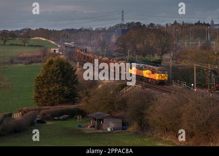 Colas Railfreight classe 56 locomotives 56094 + 56090 transportant un long train de marchandises transportant du bois sur la ligne principale de la côte ouest Banque D'Images