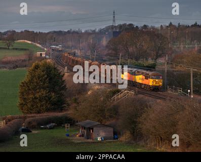 Colas Railfreight classe 56 locomotives 56094 + 56090 transportant un long train de marchandises transportant du bois sur la ligne principale de la côte ouest Banque D'Images