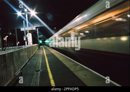 Une vue nocturne dramatique d'un train qui roule à grande vitesse à travers Hendon Station , au nord de Londres, mai 2021. Dans 10 minutes, il arrivera dans le centre de Londres Banque D'Images