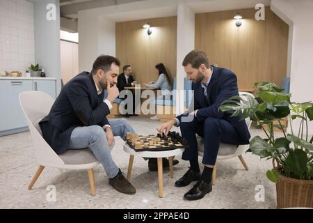 Deux hommes professionnels jouant aux échecs dans un café de bureau Banque D'Images