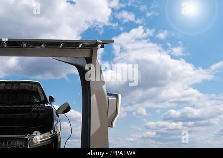 La voiture électrique est chargée à partir d'une station de charge qui prend l'énergie des panneaux solaires. Photo de haute qualité Banque D'Images