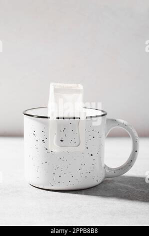 Sac de café égouttoir dans une grande tasse, Coffee Trend, méthode rapide de préparation du café moulu à l'aide du filtre de type papier Banque D'Images