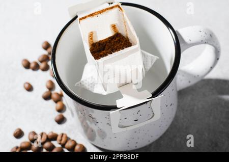 Sac de café égouttoir dans une grande tasse, Coffee Trend, méthode rapide de préparation du café moulu à l'aide du filtre de type papier Banque D'Images