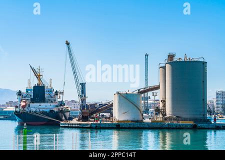 Port industriel de Malaga, Espagne. Transporteur de vrac dans le terminal de vrac sec, près des bunkers de ciment Banque D'Images