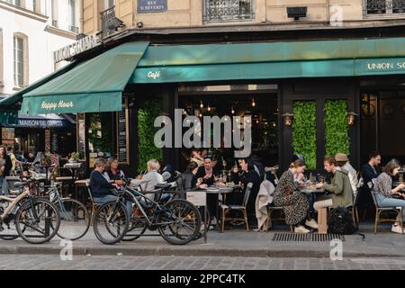 Touristes et locaux assis à l'extérieur du Bistro Union Square pour déjeuner à Paris. Banque D'Images