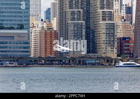 Le Cessna 208B de Tropic Oceans Airways part de la base d'hydravions New York Skyports sur l'East River. Arrière-plan:vue 34, 401 E 31st St. Banque D'Images