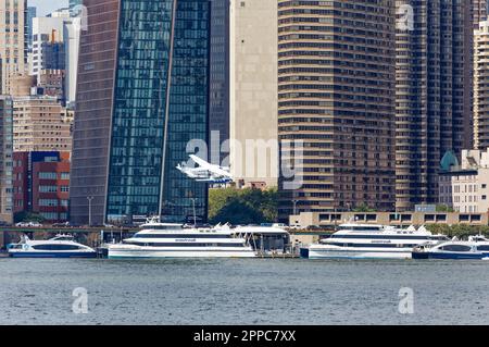 Le Cessna 208B de Tropic Oceans Airways part de la base d'hydravions New York Skyports sur l'East River. Contexte : la place du cuivre et de Manhattan. Banque D'Images