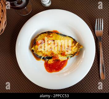 Moitié cuite au four d'aubergines gratinées au fromage Banque D'Images