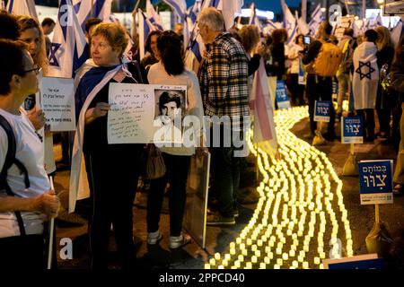 Israël. 22nd avril 2023. Les membres de la famille endeuillés tiennent une photo de leurs proches à côté de milliers de bougies « Yom Hazikaron » pour le jour du souvenir des soldats israéliens tombés et des attaques terroristes contre les victimes lors d'une manifestation contre la révision judiciaire à tel Aviv. AVR 22th 2023. (Matan Golan/Sipa USA). Credit: SIPA USA/Alay Live News Banque D'Images