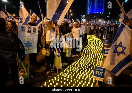 Israël. 22nd avril 2023. Les membres de la famille endeuillés tiennent une photo de leurs proches à côté de milliers de bougies « Yom Hazikaron » pour le jour du souvenir des soldats israéliens tombés et des attaques terroristes contre les victimes lors d'une manifestation contre la révision judiciaire à tel Aviv. AVR 22th 2023. (Matan Golan/Sipa USA). Credit: SIPA USA/Alay Live News Banque D'Images