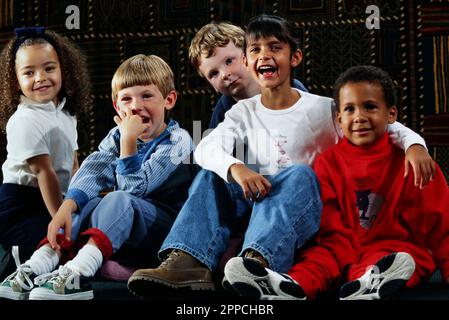 Portrait d'un groupe d'enfants multiraciaux à l'écoute et au rire Banque D'Images