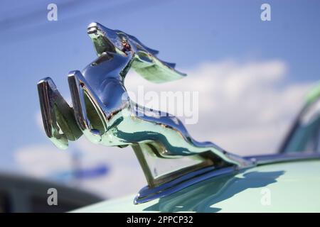 Le logo de l'usine automobile soviétique DE GAZ - un cerf en marche vu sur un capot d'une voiture rétro DE GAZ garée près du parc Gorky à Moscou. Plus d'une centaine de voitures rétro ont participé au rallye rétro 'Capital' (Stolitsa) 2023 à Moscou, en Russie. Cet événement ouvre une série de compétitions officielles de la saison 8th de la Fédération de l'automobile russe coupe en rallye avec des voitures classiques. Des marques soviétiques légendaires telles que « Volga », « Moskvich » et « Zhiguli », ainsi que des marques mondialement connues telles que Rolls Royce, Bentley, Mercedes, Porsche, Jaguar, et d'autres. Banque D'Images