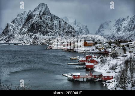 De majestueuses montagnes enneigées encerclent une baie pittoresque parsemée de plusieurs petits bateaux et de grands bateaux, créant un paysage magnifique Banque D'Images