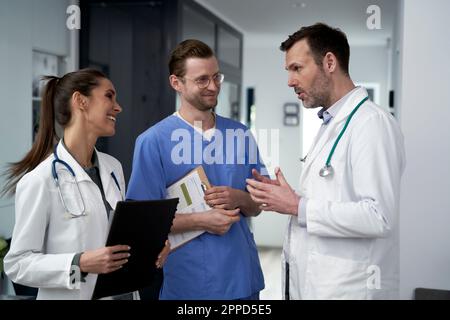 Médecin mature parlant et expliquant à des collègues en clinique Banque D'Images