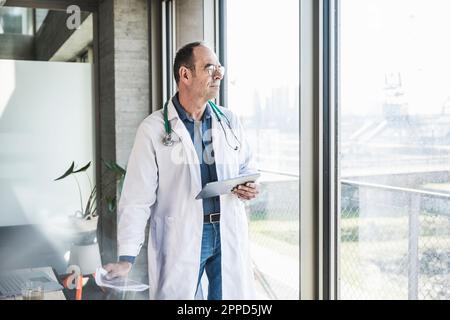 Médecin attentif regardant par la fenêtre Banque D'Images