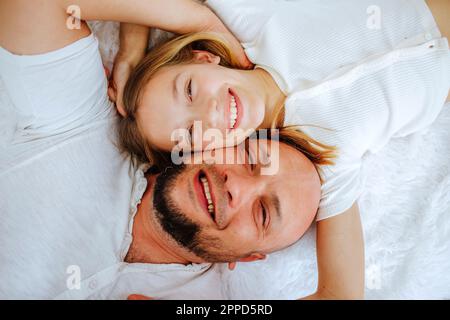 Père et fille heureux allongé sur le lit à la maison Banque D'Images