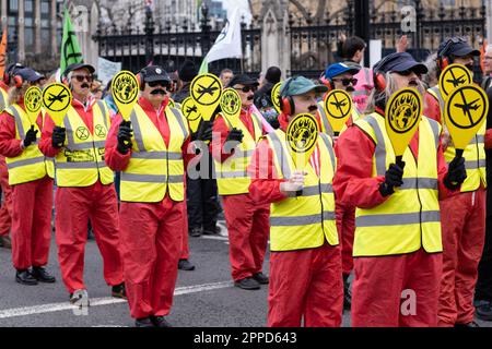 Extinction Rebellion 'couring procession', des manifestants habillés comme des marshalls d'avions défilent devant le Parlement, dans le cadre du week-end 'The Big One', Londres 2023 Banque D'Images