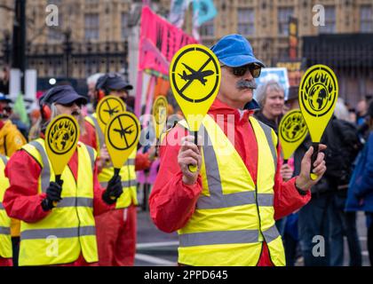 Extinction Rebellion 'couring procession', des manifestants habillés comme des marshalls d'avions défilent devant le Parlement, dans le cadre du week-end 'The Big One', Londres 2023 Banque D'Images