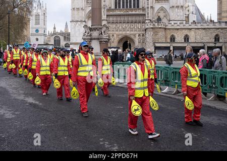 Extinction Rebellion 'couring procession', des manifestants habillés comme des marshalls d'avions défilent devant le Parlement, dans le cadre du week-end 'The Big One', Londres 2023 Banque D'Images