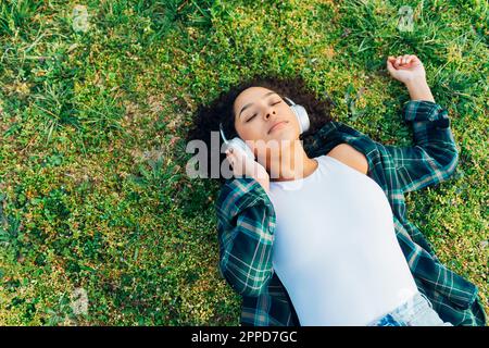 Jeune femme avec les yeux fermés se détendant et écoutant de la musique Banque D'Images