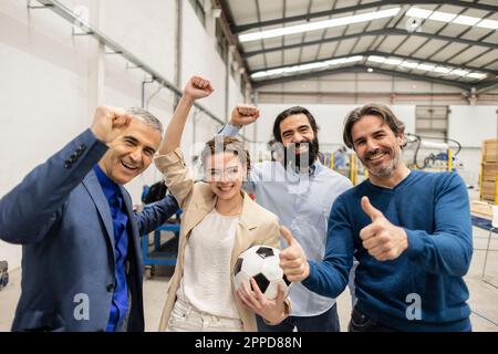 Des ingénieurs joyeux applaudissent avec leurs collègues en faisant preuve de bon sens dans l'industrie Banque D'Images