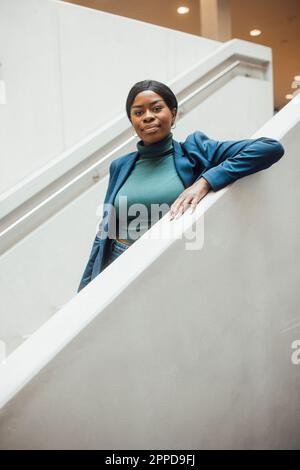 Femme d'affaires debout derrière les escaliers Banque D'Images