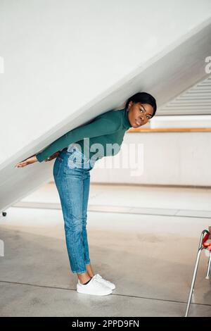 Jeune femme debout sous l'escalier Banque D'Images