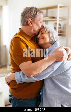 Homme âgé embrassant sur le front de la femme à la maison Banque D'Images