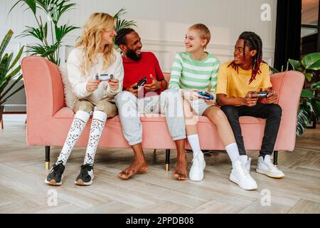 Un jeune homme heureux avec des amis qui apprécient le jeu vidéo à la maison Banque D'Images