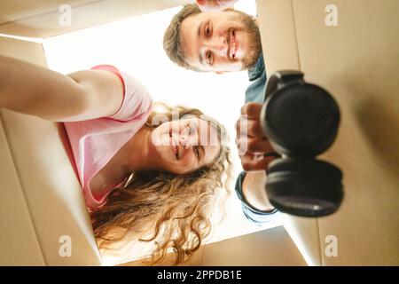 Joyeux jeune couple déballer des boîtes en carton dans la nouvelle maison Banque D'Images