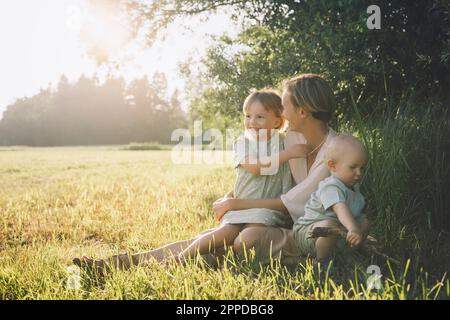 Mère heureuse avec son fils et sa fille assis à l'usine Banque D'Images