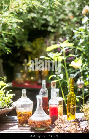 Bouteilles d'huile et de vinaigre en verre frais à la table dans le jardin Banque D'Images