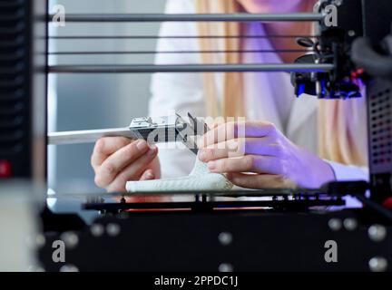 Mains de la femme utilisant un pied à coulisse à la machine à imprimer 3D en laboratoire Banque D'Images